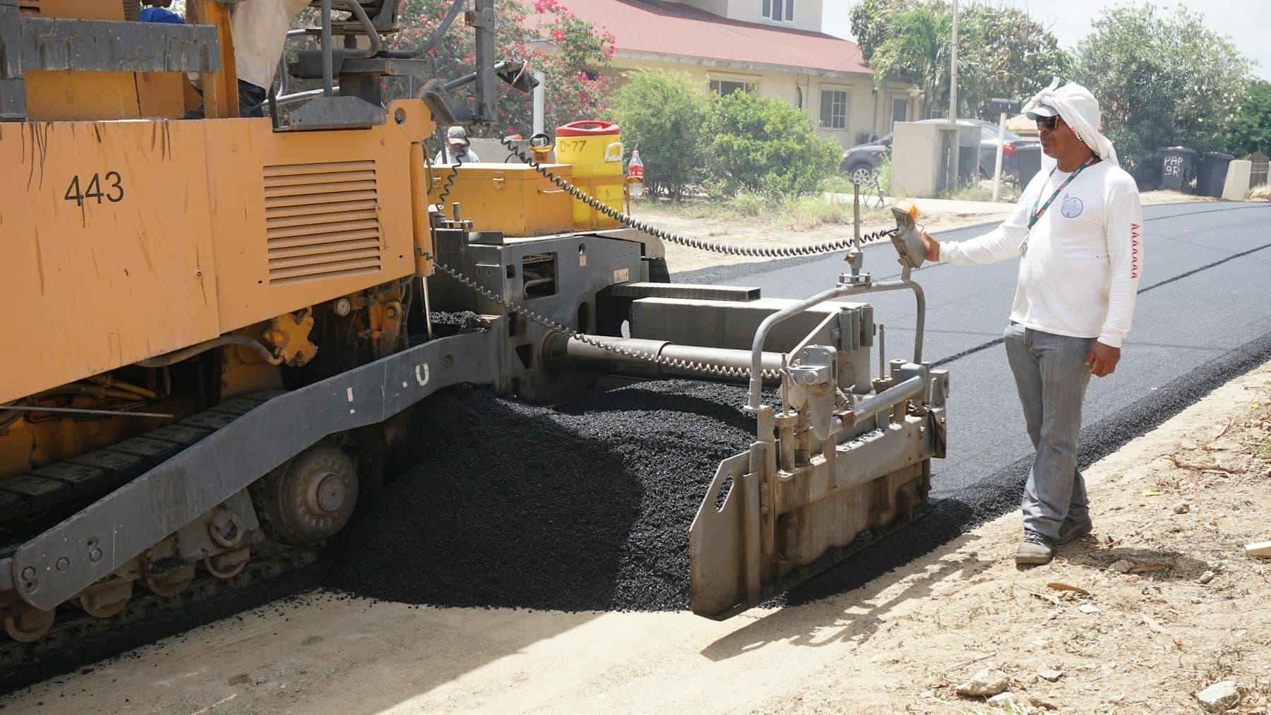 Paving crew laying fresh asphalt on a residential street