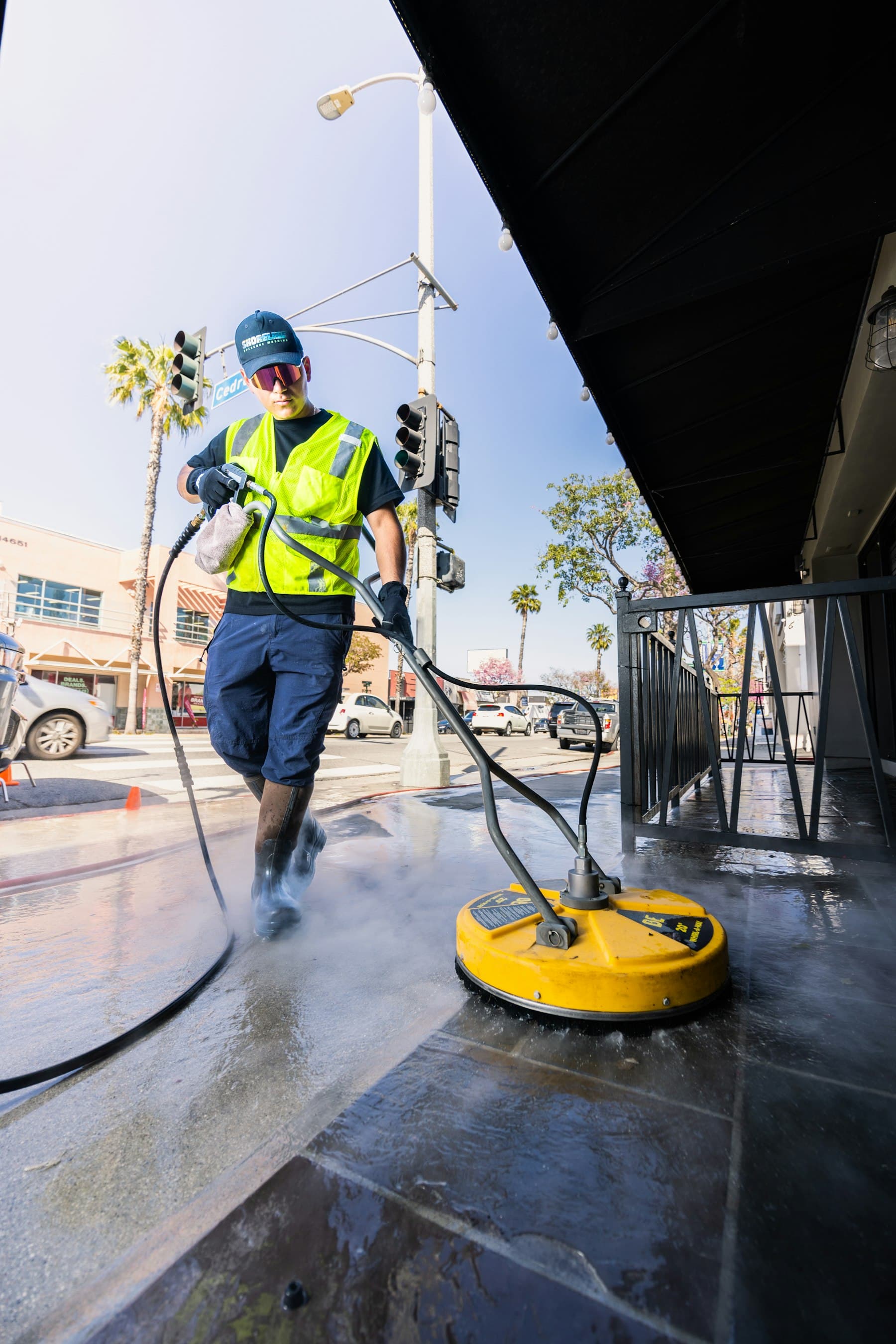 Professional pressure washing a stone surface with a surface cleaner