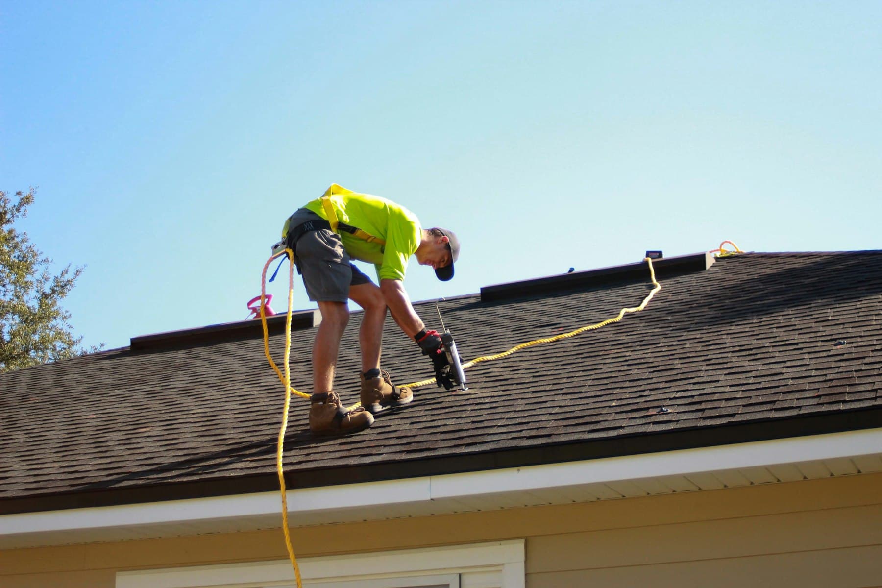 Roofer installing new shingles on a residential roof